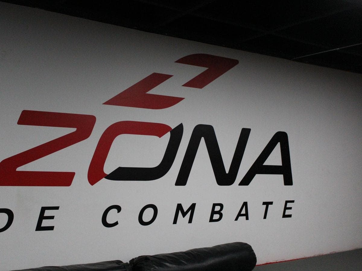 El logo de Zona de Combate en la pared del gimnasio.