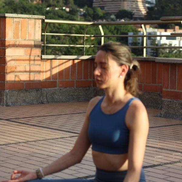 Alexandra hace yoga en una terraza.