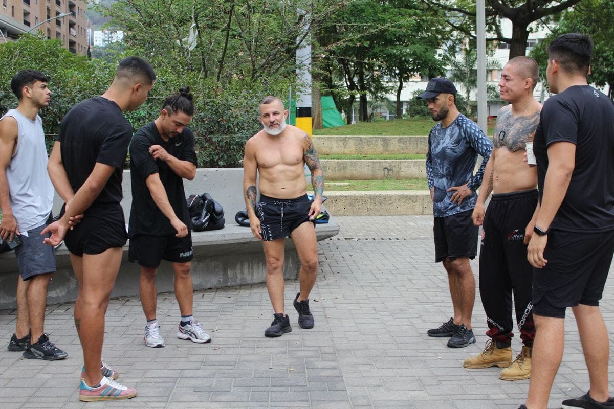 El profe Wil explica un ejercicio a su grupo en el parque.